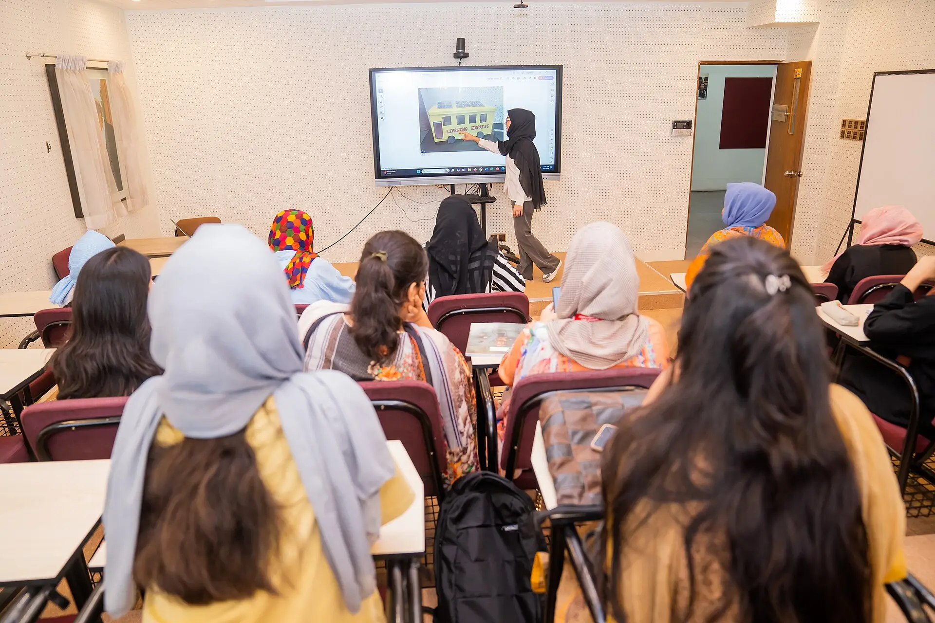Students in a Bangladesh classroom following a presentation on a screen