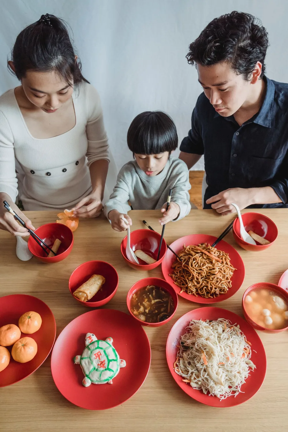 A family sharing a meal together around a wooden table