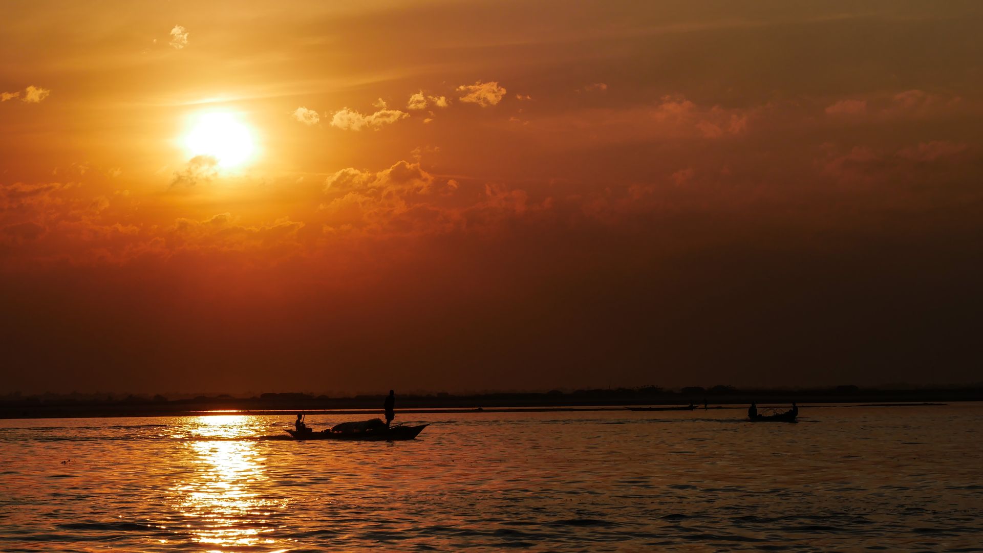A boat crossing a river in Bangladesh at golden hour